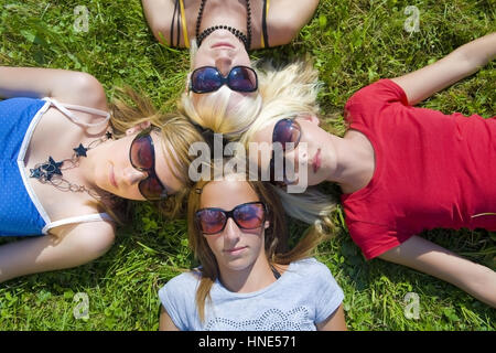 Modello di rilascio, Symbolbild Freundeskreis, Jugendliche Maedchen liegen Kopf un Kopf in der Wiese - simbolico per un circolo di amici Foto Stock