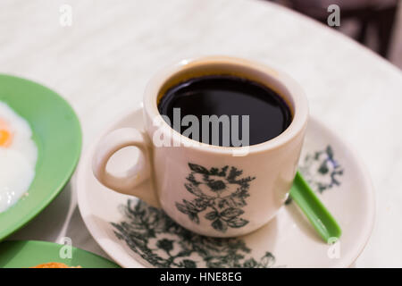 Nero caffè tradizionale colazione Singapore chiamato Kaya toast, marmellata di noce di cocco e semi-uova sode, Tradizionale Cinese orientale caffè nella tazza vintage. Foto Stock