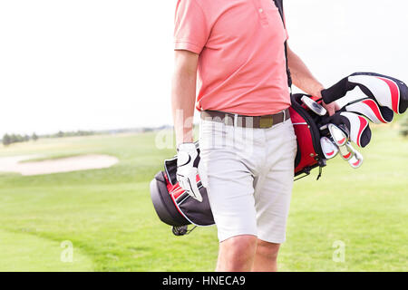 Sezione mediana dell'uomo con golf club borsa permanente al corso Foto Stock