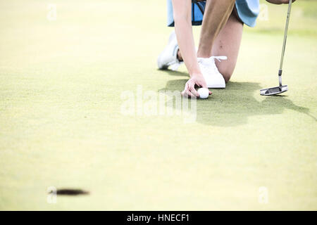 Sezione bassa della donna mettendo a sfera con campo da golf Foto Stock