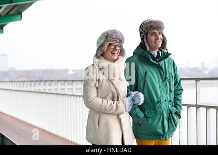 Coppia felice camminando sul marciapiede durante il periodo invernale Foto Stock