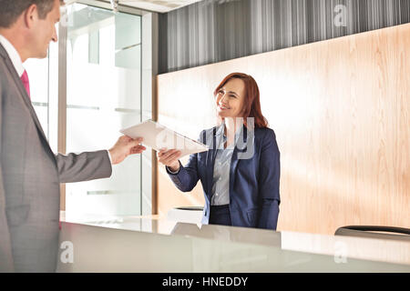 Imprenditore documento di ricezione dai receptionist in office Foto Stock