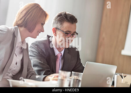 Imprenditore e imprenditrice discutendo mentre a pranzo in ufficio Foto Stock