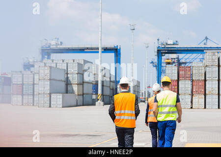 Vista posteriore dei lavoratori a piedi in cantiere di spedizione Foto Stock