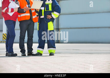 Sezione bassa dei lavoratori di discutere in cantiere di spedizione Foto Stock