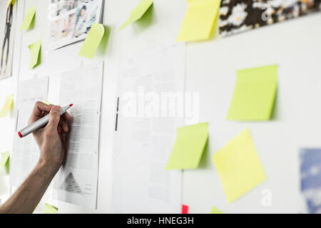 Immagine ritagliata di imprenditore il la scrittura a mano su un foglio di carta in ufficio Foto Stock