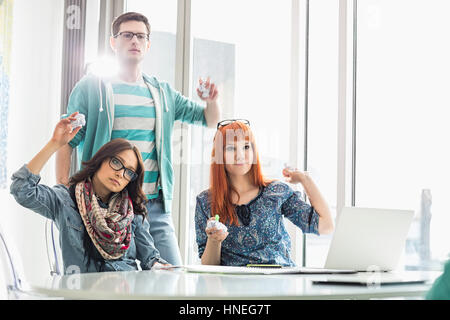 Arrabbiato gli imprenditori lanciando palle di carta in ufficio creativo Foto Stock