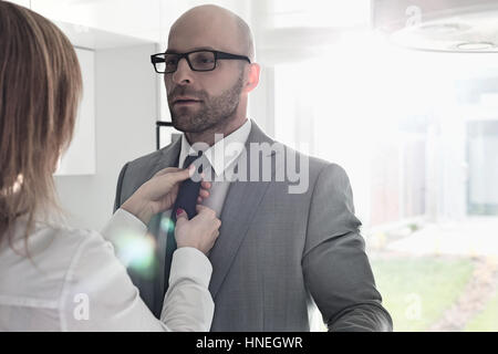 Donna Uomo d'affari di regolazione del tirante a casa Foto Stock