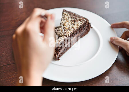 Close-up di donna di mano che tiene la forcella per pasticceria al cioccolato Foto Stock