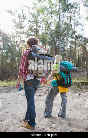 Vista posteriore di escursionismo coppia con zaini passeggiate in foresta Foto Stock