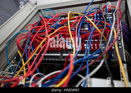 Basso angolo di intreccio di cavi in sala server presso la stazione televisiva di Foto Stock