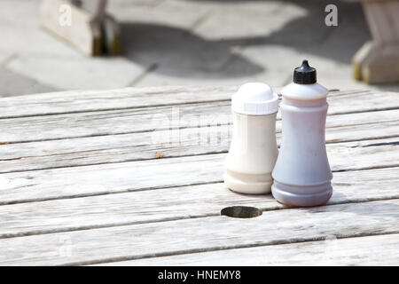 Sale e aceto bottiglie sul tavolo di legno Foto Stock