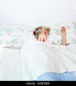 Senior donna che dorme nel letto di casa Foto Stock