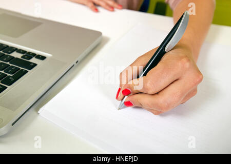 Vista ravvicinata di giovani womans la scrittura a mano su carta Foto Stock