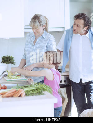 Famiglia facendo una sana insalata in cucina Foto Stock