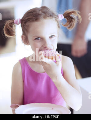 Ragazza giovane di mangiare la torta in cucina Foto Stock