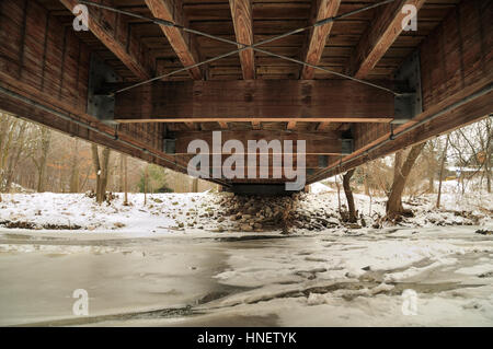 Sotto il ponte in legno sul fiume in inverno (Etobicoke creek, Brampton, ON, Canada) Foto Stock