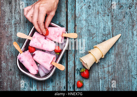 Processo di decorare con frutti di bosco dessert gelato Foto Stock