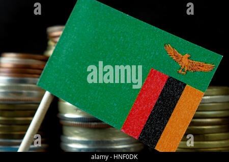 Zambia bandiera sventola con la pila di denaro monete macro Foto Stock