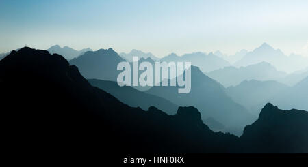 Spettacolare blu ciano e gamme della montagna di Silhouette. Vetta le Croci visibili. Foto Stock