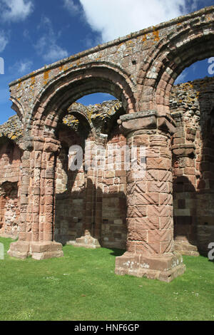 Archetti romanici e colonne in Lindisfarne Priory rovine. Le colonne incise sono simili alle iscrizioni in Durham Cathedral. Foto Stock