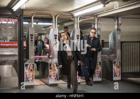 Pendolari andare attraverso i tornelli a 47-50th Sts. Il Rockefeller Center stazione della metropolitana durante la serata rush hour in midtown Manhattan. Foto Stock