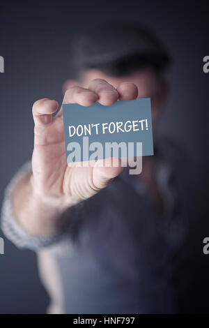 Primo piano dell'uomo in possesso di un biglietto da visita con le parole non dimenticate Foto Stock