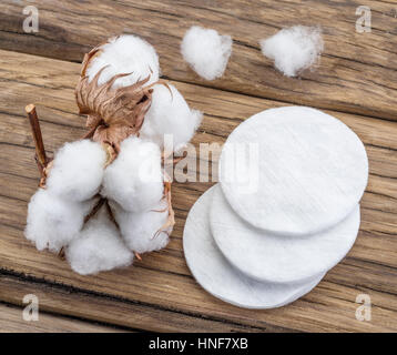 Soffice batuffolo di cotone e bastoncini di cotone e piazzole di contatto su un tavolo di legno. Foto Stock