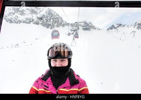 Ritratto di giovane sciatore, ragazza adolescente, in una macchina di cavo a montagne alpine. Foto Stock