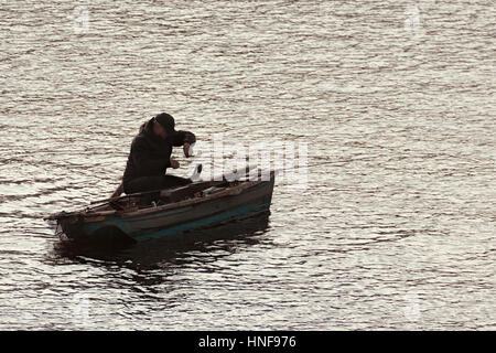 Praga, Repubblica Ceca - 15 Ottobre 2016: pescatore godendo il suo hobby su di un piccolo e tradizionale vintage barca sul fiume Vltava nel centro storico. Foto Stock