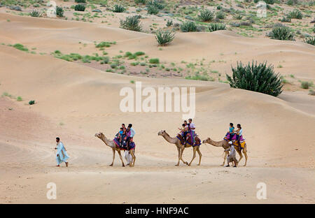 I turisti a cavallo di cammelli su Sam dune nel deserto parco nazionale nel Grande deserto di Thar,vicino a Jaisalmer, Rajasthan, India Foto Stock