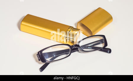 Un elegante occhiali nero e oro caso per loro. Isolare bianco. Foto Stock