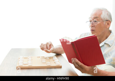 Un anziano uomo giocando un problema shogi Foto Stock