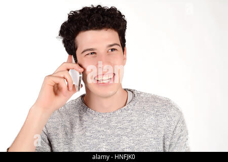 Ritratto di un giovane uomo bello parlare al telefono. Isolato sullo sfondo bianco. Foto Stock