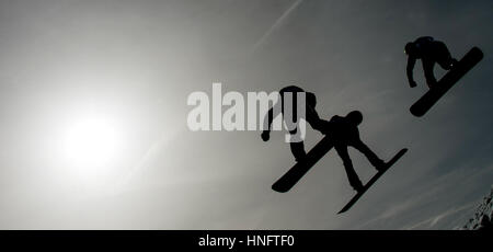 Feldberg, Germania. 12 Feb, 2017. Snow boarders saltare in aria contro la luce durante la snow board cross di Coppa del Mondo a Feldberg, Germania, 12 febbraio 2017. Foto: Patrick Seeger/dpa/Alamy Live News Foto Stock