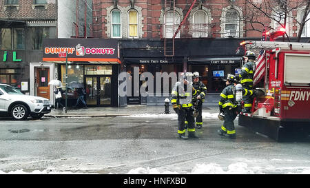 La città di New York, Stati Uniti d'America. 12 Febbraio, 2017. FDNY vigili del fuoco in attesa sotto la pioggia ad ovest sulla terza strada. New York è stata sotto nuvole temporalesche durante tutto il weekend. Credito: Ward Pettibone/Alamy Live News Foto Stock