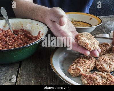 Per la cottura delle costolette. 12 Feb, 2017. L'uomo produce cotolette Credit: Igor Golovniov/ZUMA filo/Alamy Live News Foto Stock