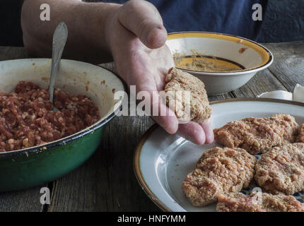 Per la cottura delle costolette. 12 Feb, 2017. L'uomo produce cotolette Credit: Igor Golovniov/ZUMA filo/Alamy Live News Foto Stock