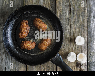 Per la cottura delle costolette. 12 Feb, 2017. Padella con costolette fritte su un vecchio weathered tavolo in legno Credito: Igor Golovniov/ZUMA filo/Alamy Live News Foto Stock