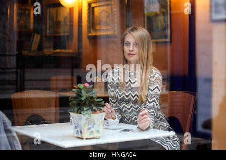 Bellissima ed elegante donna in una città elegante cafe. Uno stile di vita urbano Foto Stock