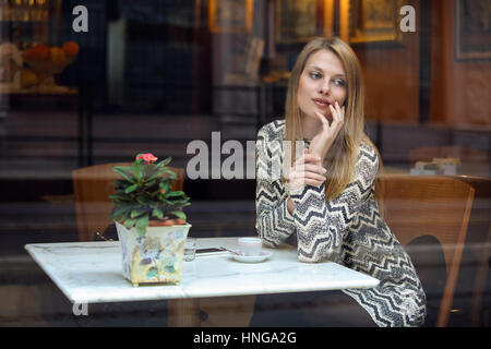 Elegante giovane donna in un elegante cafe. Urban shot Foto Stock