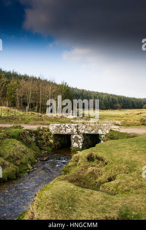 Un piccolo ponte di granito su un piccolo fiume su terreni accidentati Tor, designato come una zona di straordinaria bellezza naturale a Bodmin Moor in Cornovaglia. Foto Stock
