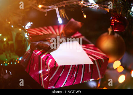 Giocattoli di natale su albero con decorazioni e confezione regalo Foto Stock