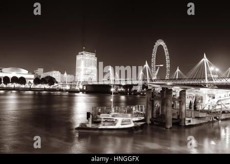 Il fiume Tamigi vista notturna con edifici per uffici, barca e London Eye in bianco e nero. Foto Stock