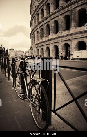 Street view con la bicicletta e il Colosseo a Roma, Italia. Foto Stock