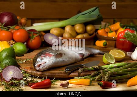 Tutta la trota con materie prime e ingredienti vegetali Foto Stock