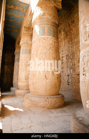 Dipinti egiziani, carving figure e geroglifici in colonne e una parete di pietra miliare tempio di Ramses o Ramesse III a Medinet Habu, monumento in Luxo Foto Stock