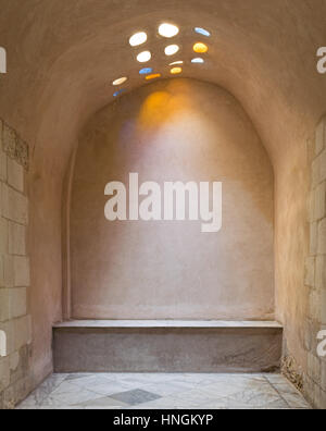 Arcuata di muro di pietra illuminato da colorata circolare sul tetto a forma di fori in corrispondenza di una storica e tradizionale stile turco (bagno turco Hamam inale), Cairo medioevale, Egitto Foto Stock