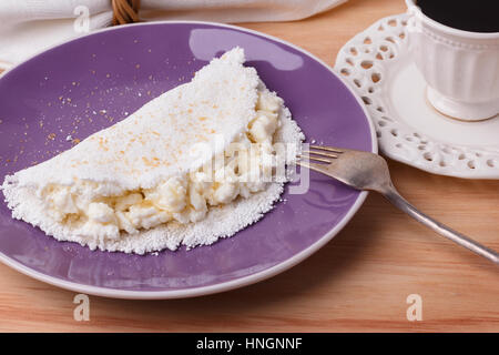 Casabe (ingaggiami, beiju, bob, biju) - flatbread di manioca (tapioca) con ricotta e miele e la tazza di caffè su sfondo di legno. Messa a fuoco selettiva Foto Stock