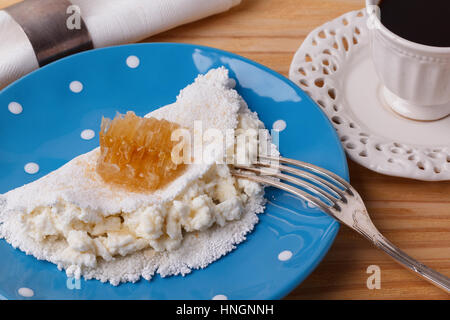 Casabe (ingaggiami, beiju, bob, biju) - flatbread di manioca (tapioca) con ricotta e miele e la tazza di caffè su sfondo di legno. Messa a fuoco selettiva Foto Stock